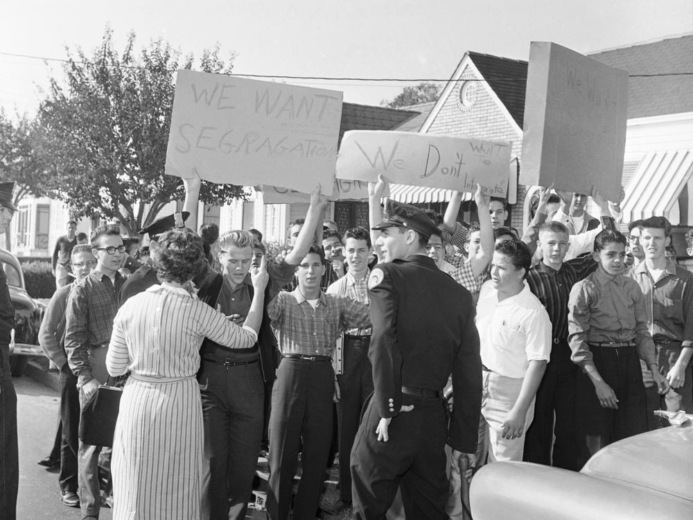 With signs calling for segregation, a crowd gathers outside the William Frantz Elementary School in New Orleans on Monday, Nov. 14, 1960, the first day of classes for 6-year-old Black student Ruby Bridges.