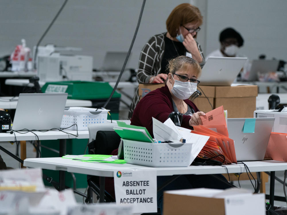 Election personnel sort ballots in preparation for an audit at the Gwinnett County Board of Voter Registrations and Elections offices on Saturday in Lawrenceville, Ga. President Trump's attempt at legal action to contest the results of the election have so far been mostly unsuccessful.