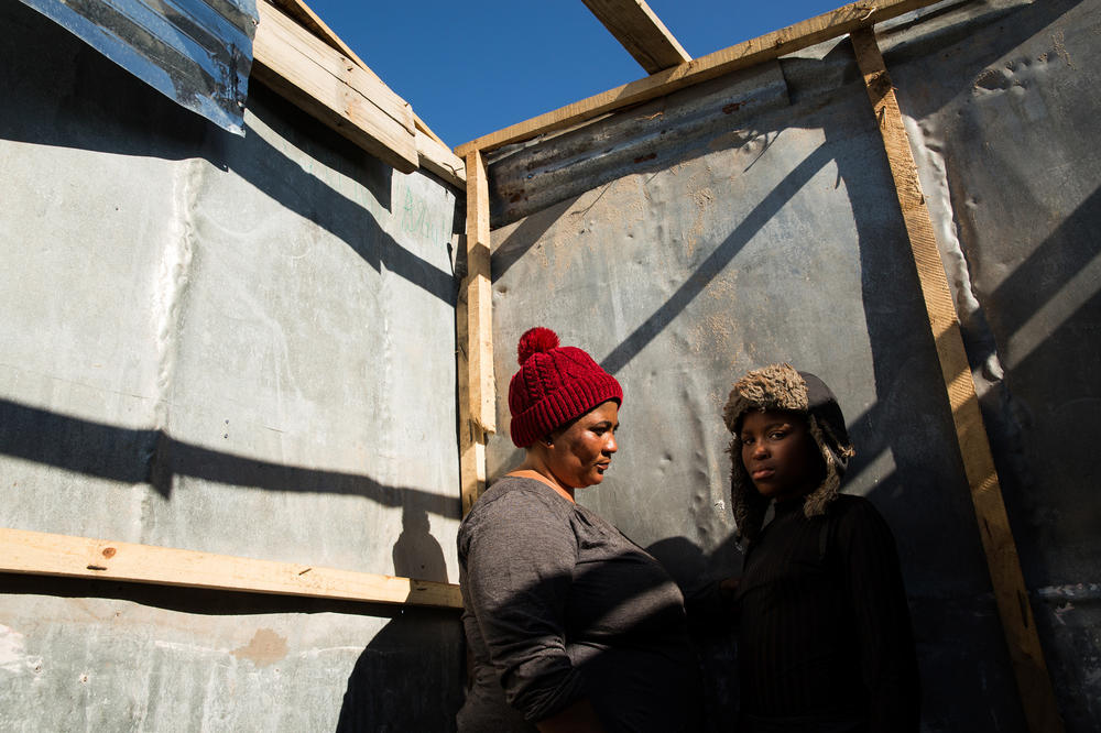 Noluthanda Gwanya and her daughter Inathi Sigijimi, 12. A storm the night before flooded their shack and blew off the roof, and they had to shelter with friends. 