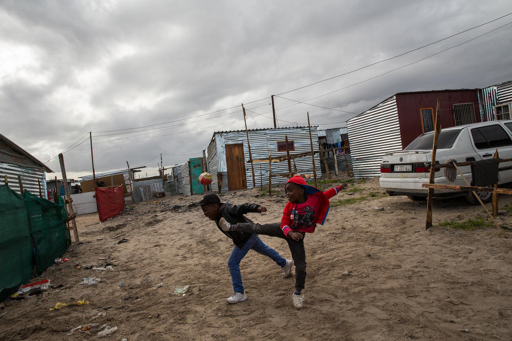Kids play in the alleys of the Covid settlement.