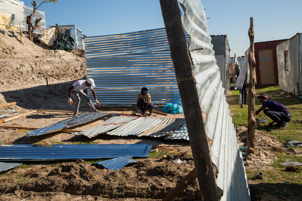 With a new spot staked out, a group of men set about setting up a shack using readymade parts of tin as well as improvised materials. They'll finish the job in just a few hours.