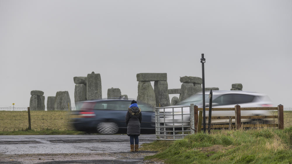 Cars drive on the A303 road near Stonehenge.
