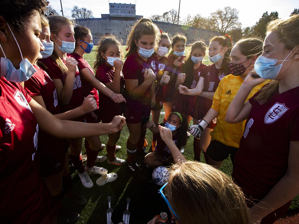 The Lowell High School girls soccer team fist bumps before a game this month in Massachusetts. The coronavirus pandemic has curtailed youth athletics leaving some students scrambling for opportunities.