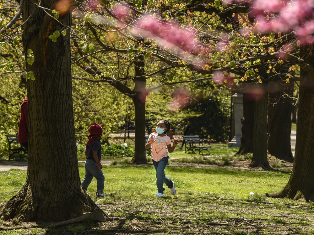 A child wears a protective mask while playing in April in Prospect Park in the Brooklyn borough of New York City.