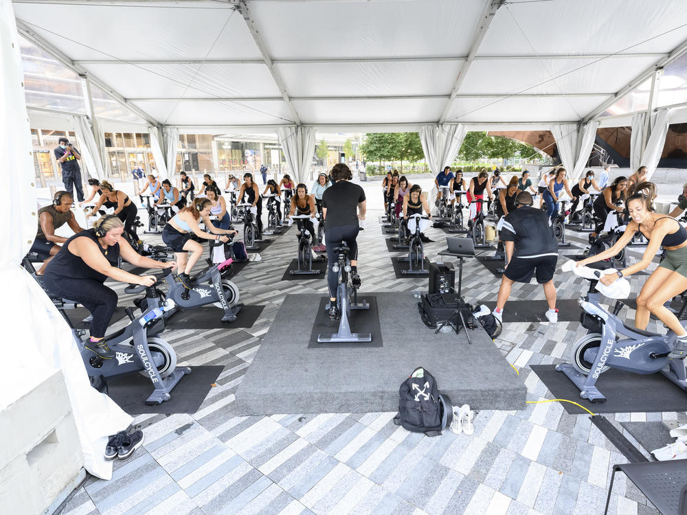 People attend a SoulCycle class under an outdoor tent in September in New York City.