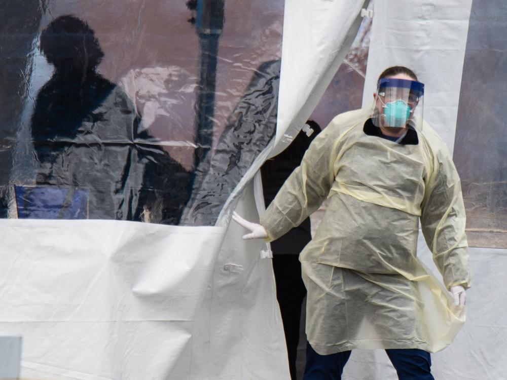 A health professional walks out of a drive-through coronavirus testing site at the University of Dayton in Ohio earlier this year. Ohio will go on a statewide curfew Thursday for at least three weeks.