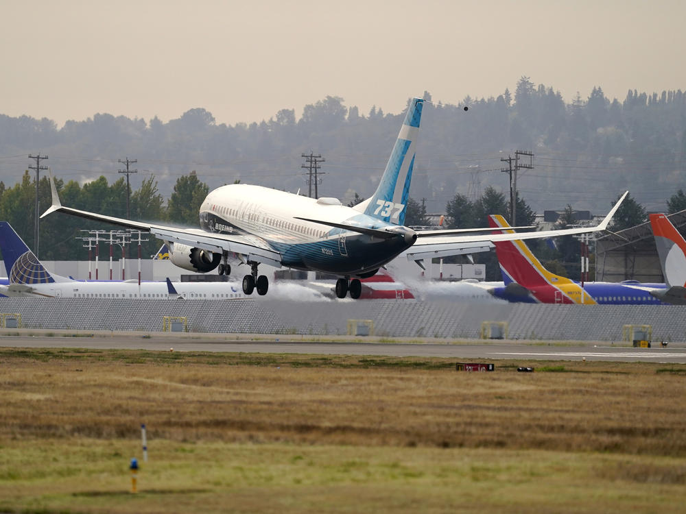 A Boeing 737 Max jet, piloted by Federal Aviation Administration chief Steve Dickson, flies past parked Boeing jets as it prepares to land at Boeing Field following a test flight in September.