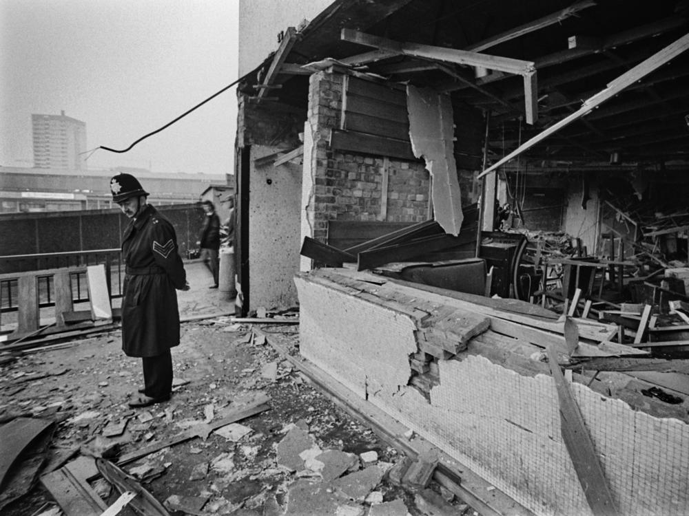 A police officer stands before damage caused by one of two pub bombings in 1974 in Birmingham, England.