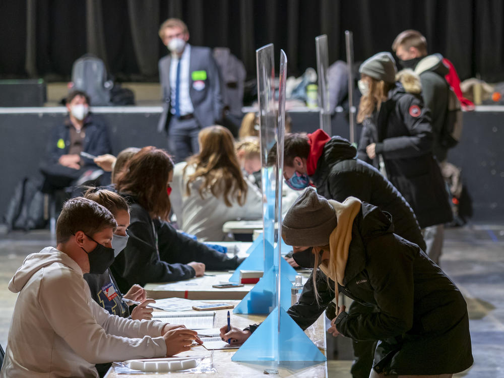 Poll workers check voters' identifications on Election Day at the Orpheum Theater in Madison, Wis. The Trump campaign has announced it is filing for a recount in two Wisconsin counties.