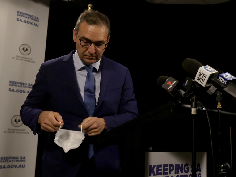 South Australian Premier Steven Marshall takes his mask off as he announces a six-day lockdown for South Australia that takes effect midnight Thursday local time.