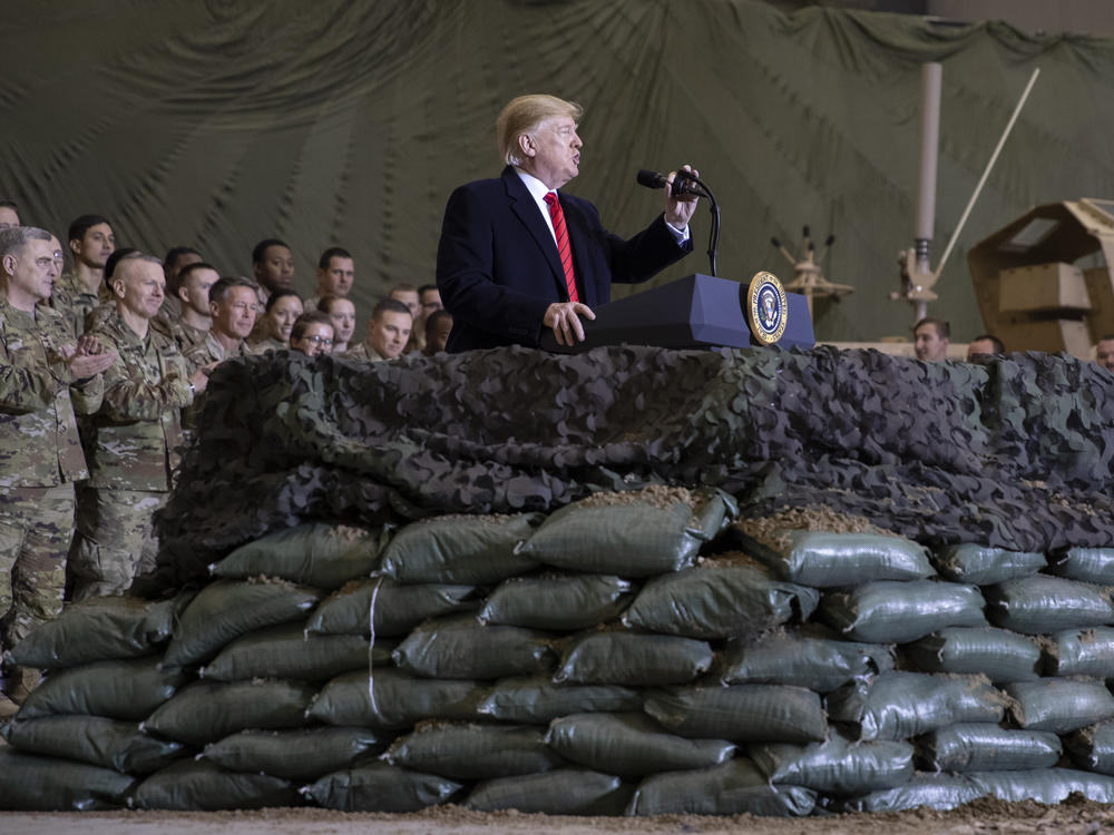 President Trump speaks to U.S. troops at Bagram Airfield, Afghanistan, on Thanksgiving Day 2019. The Trump administration says it's cutting U.S. forces from 4,500 to 2,500 troops in Afghanistan, one of several abrupt military moves announced recently.