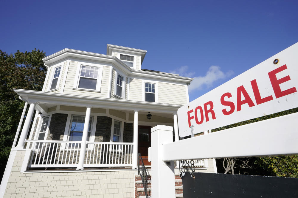 A for sale sign is displayed in front of a house in Westwood, Mass. Home prices hit a new record in October as the number of homes for sale hit an all-time low.