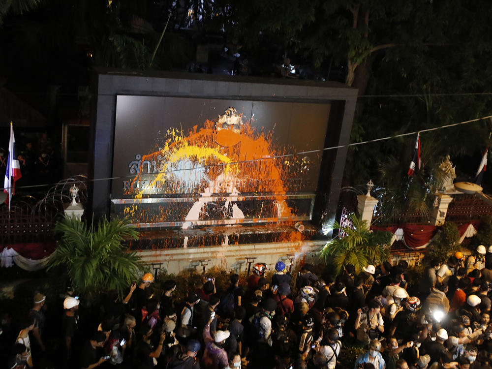 Pro-democracy protesters splash colored paint on the police headquarters sign in Bangkok, Thailand, on Wednesday.