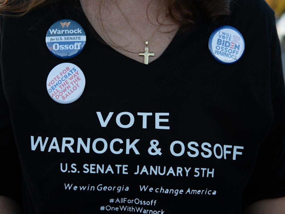 A supporter wears a homemade T-shirt to promote Democratic U.S. Senate candidates Jon Ossoff and Raphael Warnock of Georgia during a rally on Nov.15, in Marietta, Ga.