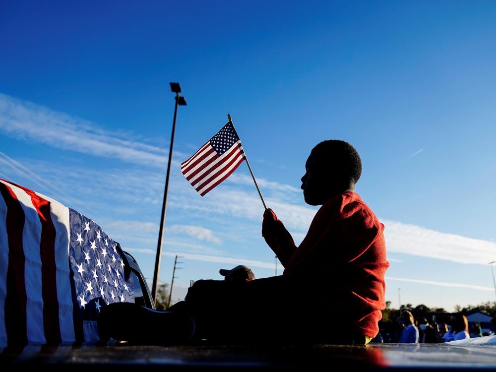 Xavier Watts, 9, waves an American flag during a campaign rally for Georgia Democratic U.S. Senate candidates Jon Ossoff and Raphael Warnock on Nov. 15 in Marietta, Ga.