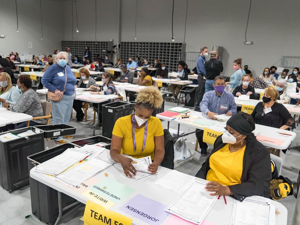 Gwinnett County election workers handle ballots Monday in Lawrenceville, Ga., as part of the state's recount for the 2020 presidential election.