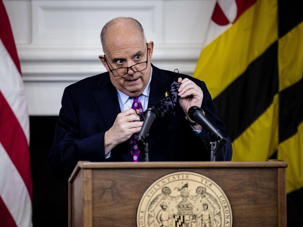Maryland Governor Larry Hogan takes his mask off as he arrives for a press conference to address COVID-19 concerns in Annapolis, the state capital, on Tuesday.