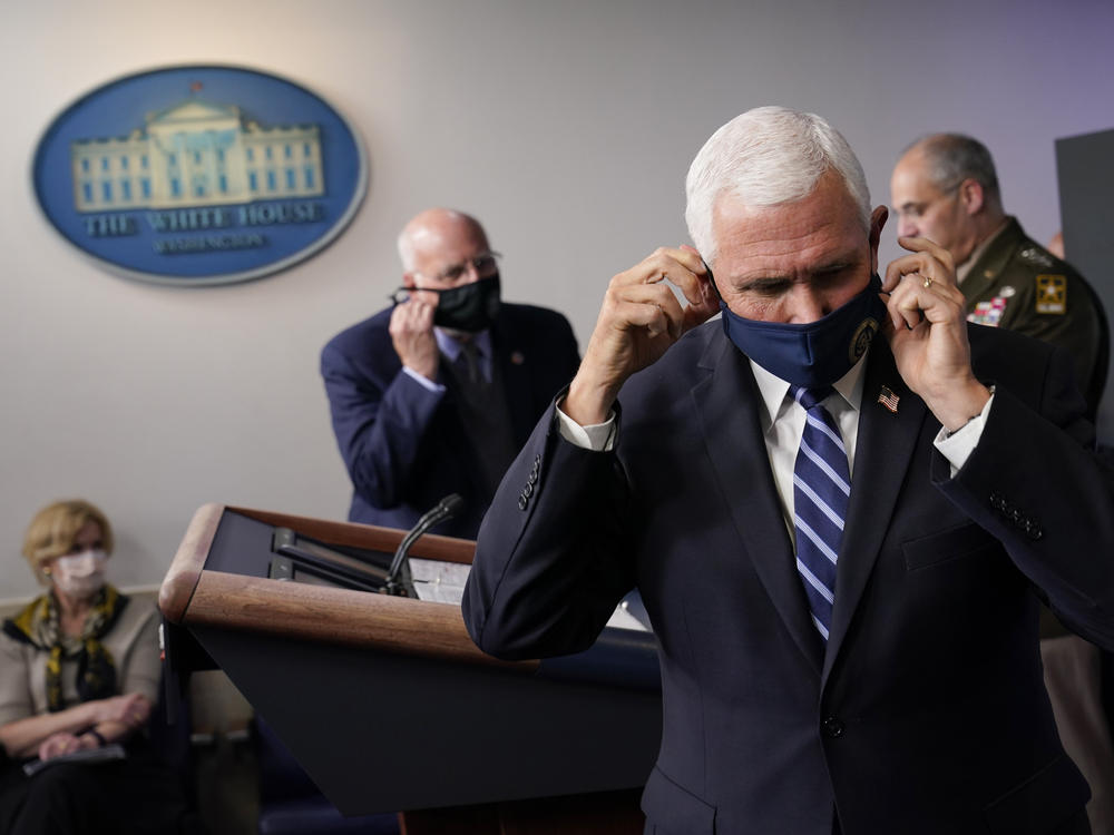 Vice President Pence adjusts his face mask during a news conference with the coronavirus task force at the White House on Thursday.