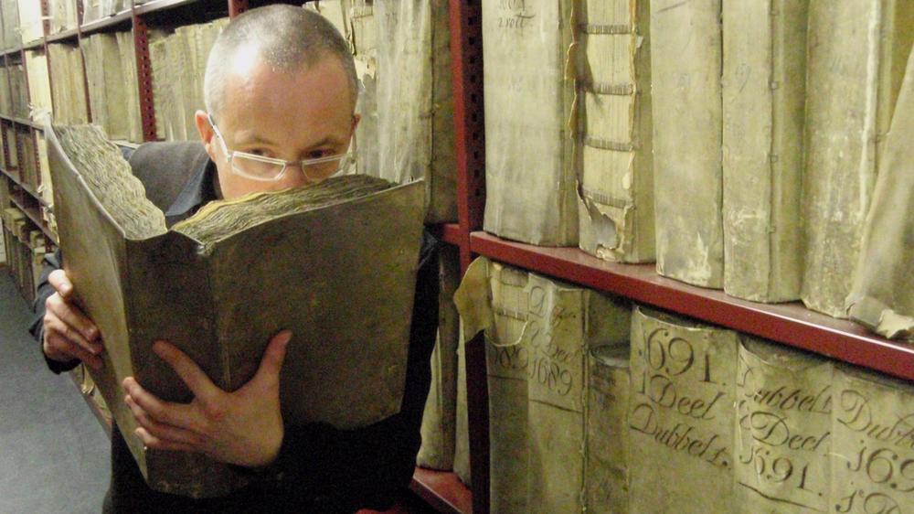 Professor Matija Strlic of the Odeuropa team smells a historic book in the National Archives of The Netherlands.