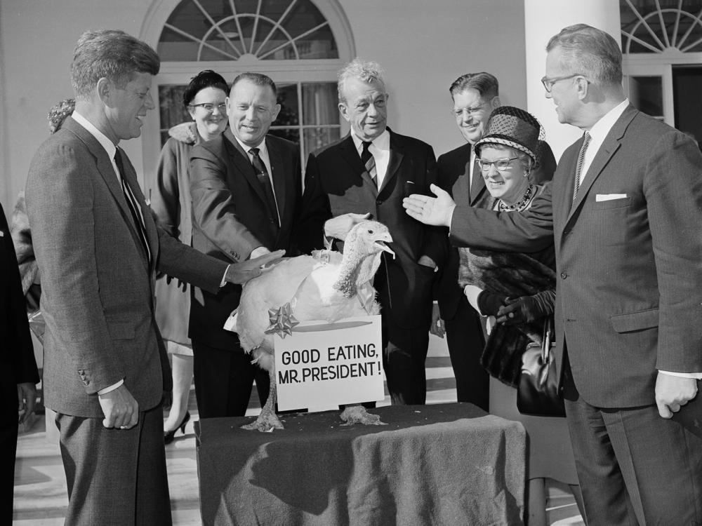 President John F. Kennedy reaches out to touch a turkey presented to him at the White House from the turkey industry in 1963.
