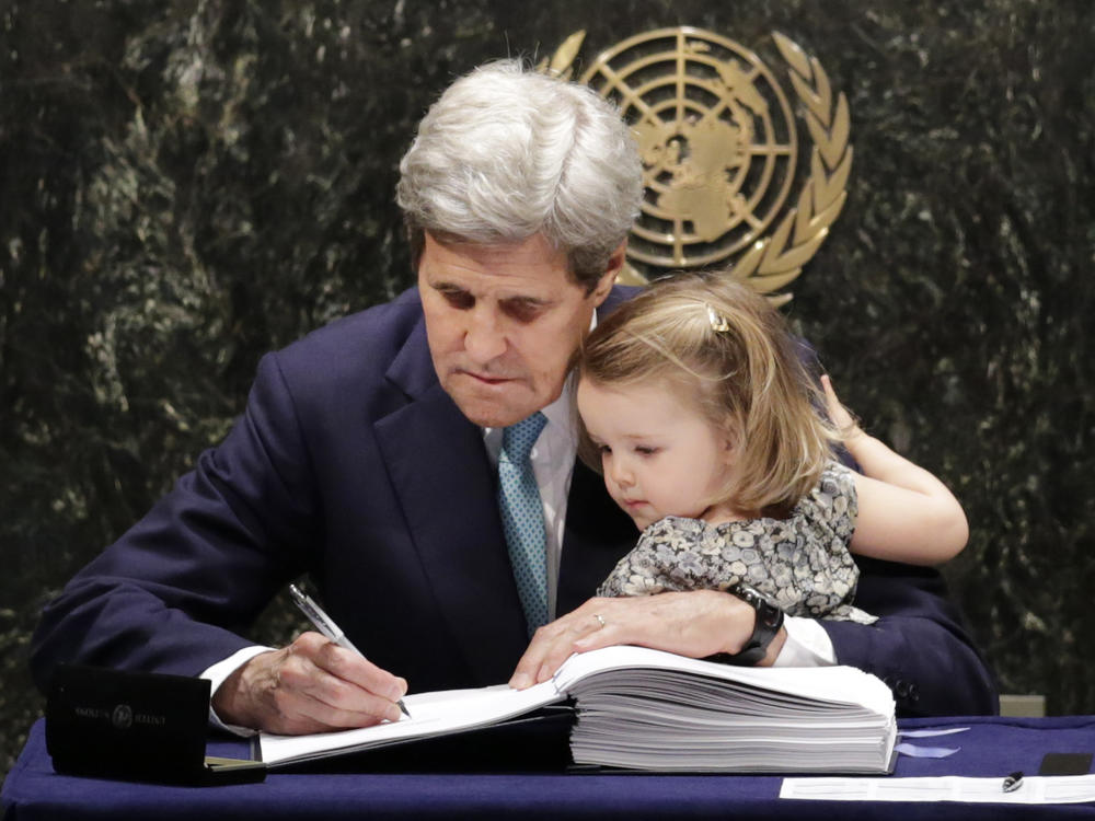 Then-Secretary of State John Kerry holds his granddaughter as he signs the Paris Agreement on climate change in April 2016. Kerry has been chosen as climate envoy in the incoming Biden administration.