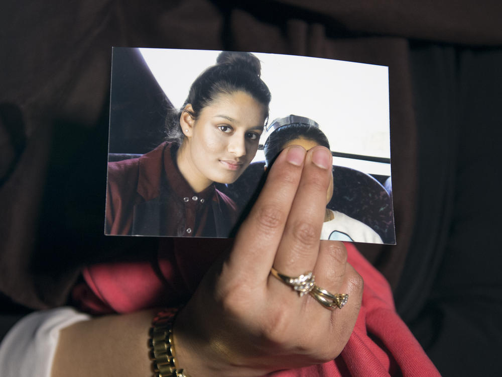 The eldest sister of Shamima Begum holds her sister's photo in 2015. Begum, who left London to join the Islamic State organization as a teenager, is now trying to return to the U.K. to argue that her British citizenship should not have been revoked.