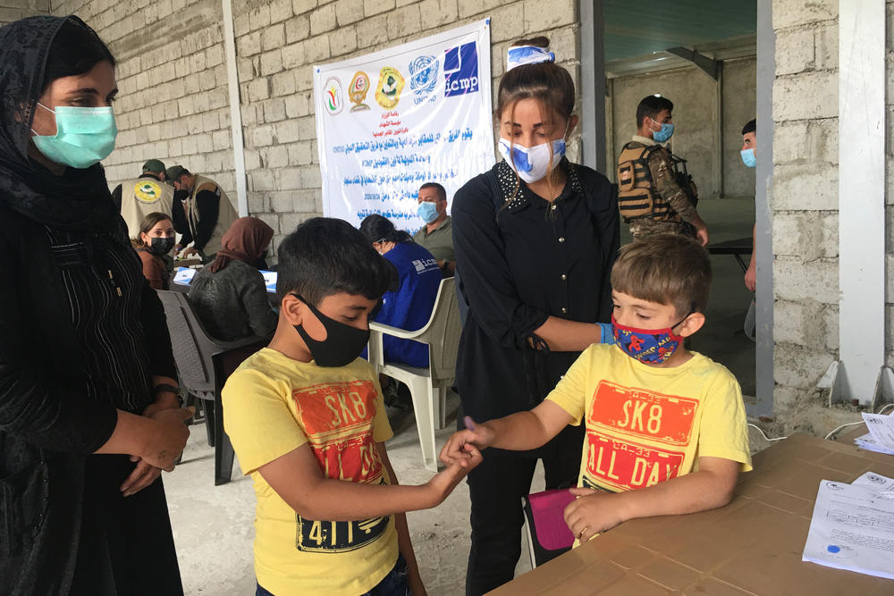 Kamo Zandinan with her youngest sons Arkan (left), 8, and Rakan, 6, at a testing center in the Yazidi village of Cocho, Iraq, in late October. The Hague-based International Commission for Missing Persons was taking blood samples for DNA tests to try to identify the remains of Yazidis killed in the genocide waged by ISIS, now being exhumed from mass graves.