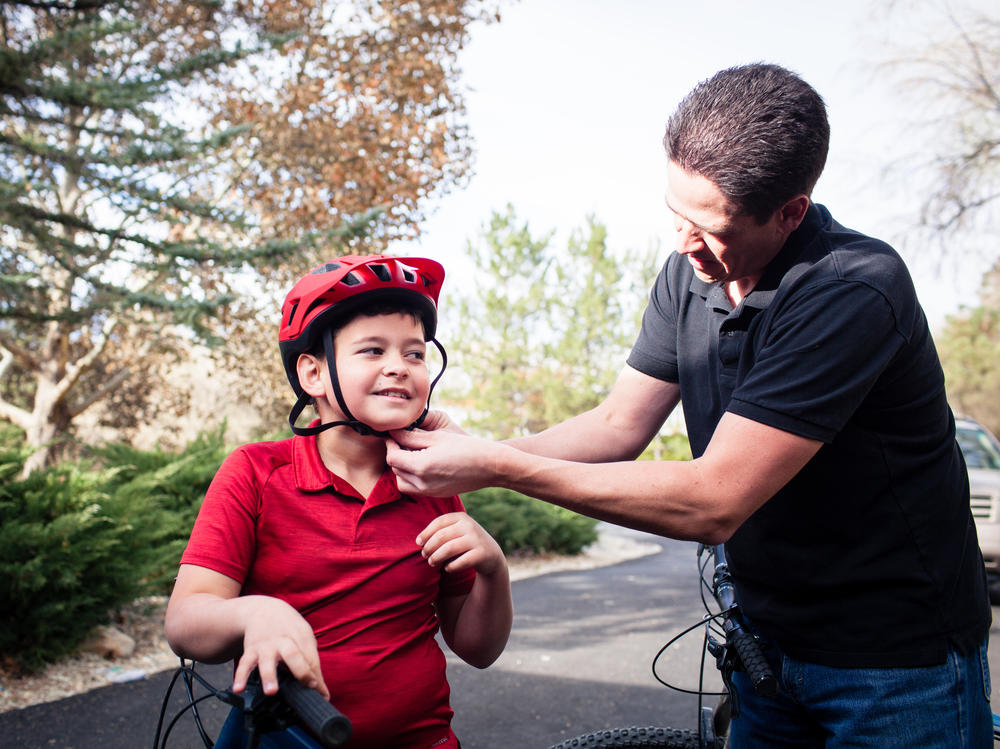 Adam Woodrum and his son, Robert, get ready for a bike ride near their home in Carson City, Nev., this month. During the summer, Robert had a bike accident that resulted in a hefty bill from the family's insurer.