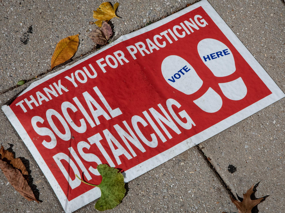 A social distancing sign on the ground. 