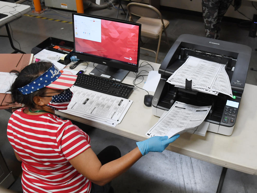 An election worker scans mail-in ballots at the Clark County Election Department last month in North Las Vegas, Nev.