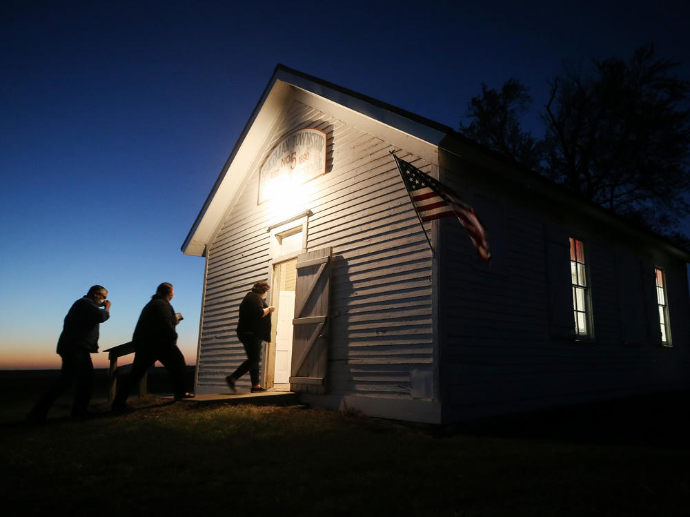 Voters enter a polling place at dusk on Election Day to cast their ballots at Sherman Township Hall, a former one-room schoolhouse, in Zearing, Iowa.