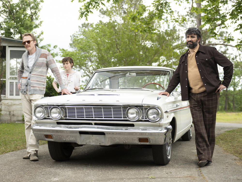 L to R: Frank (Paul Bettany) Beth (Sophia Lillis) and Walid (Peter Macdissi) pull up to the bumper in <em>Uncle Frank</em>.