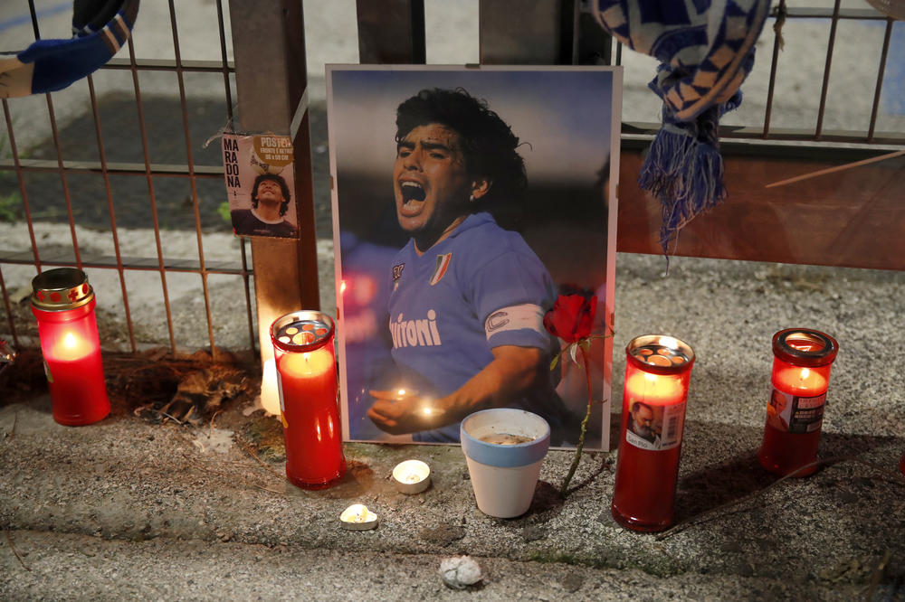 Candles are placed next to a picture of Maradona outside the San Paolo Stadium in Naples, Italy.
