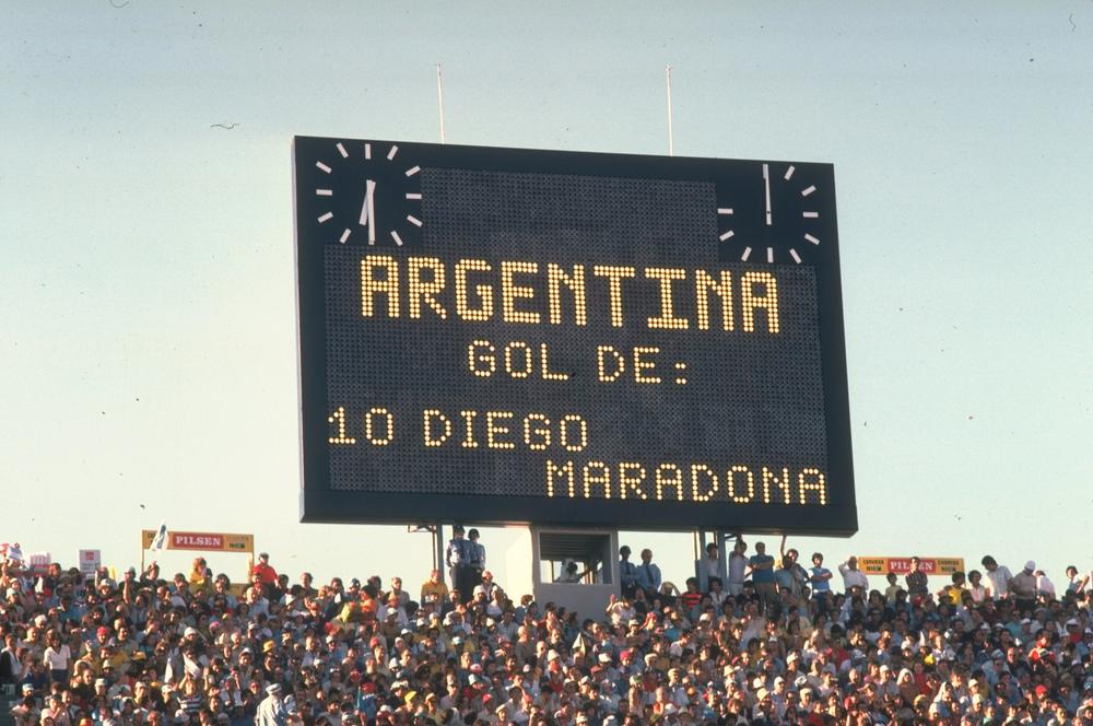 A scoreboard shows a score from Maradona at a match in 1981.