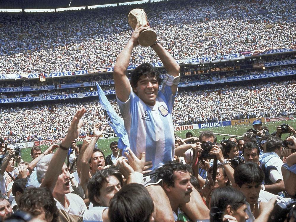 Diego Maradona holds up his team's trophy after Argentina's 3-2 victory over West Germany at the World Cup final soccer match at Azteca Stadium in Mexico City in 1986. The Argentine soccer great who was among the best players ever, died from a heart attack on Wednesday.