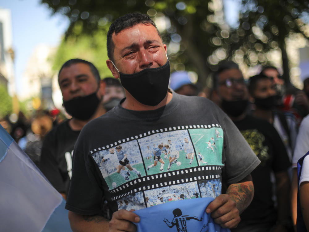 A man cries as he waits in a line outside the presidential palace to pay his final respects to Diego Maradona, in Buenos Aires on Thursday.