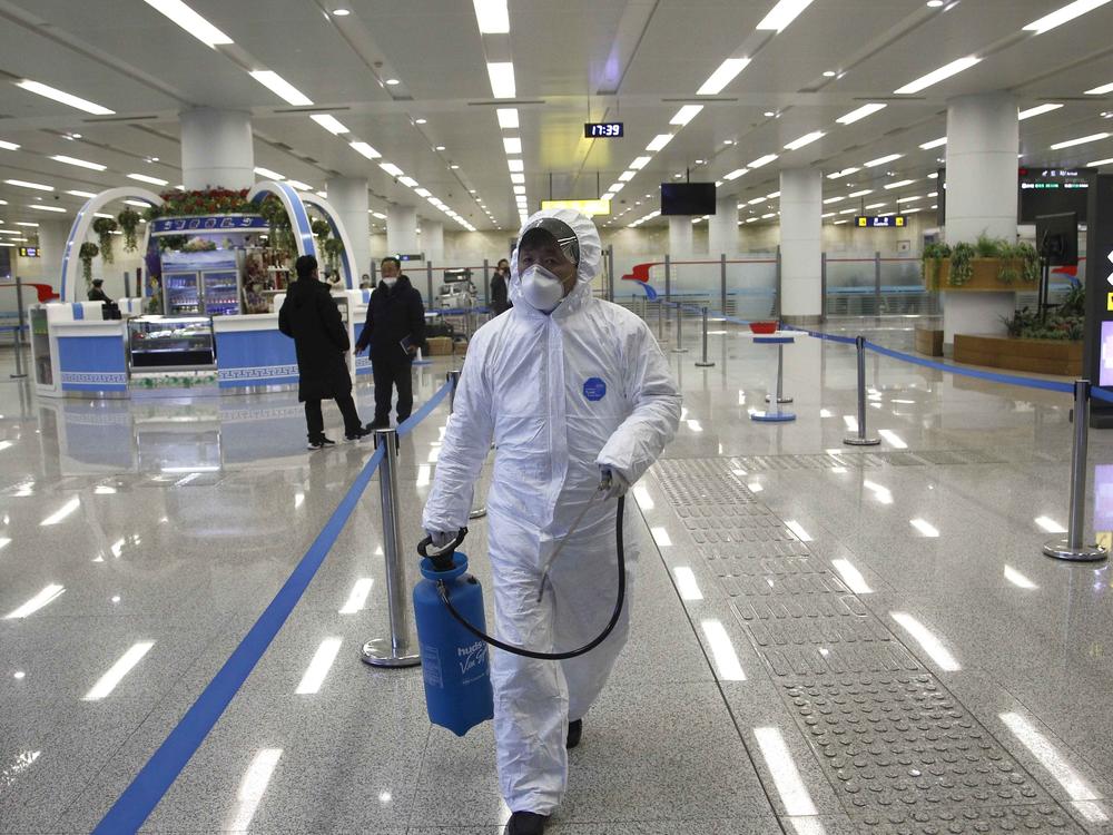 North Korean State Commission of Quality Management staff in protective gear carries a disinfectant spray can as personnel check the health of travelers and inspect goods delivered via the borders at the Pyongyang Airport in North Korea, on Feb. 1.