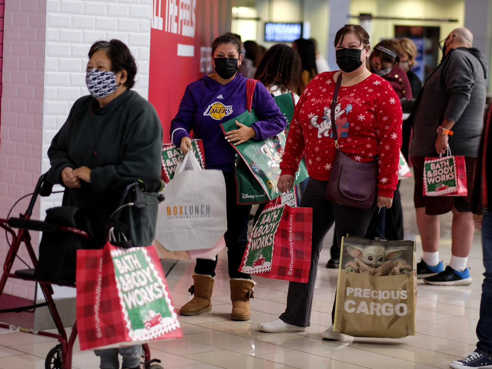 Black Friday shoppers wearing face masks wait in line to enter a store at the Glendale Galleria in Glendale, Calif., on Friday.