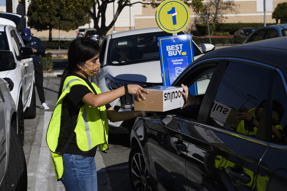 A Best Buy employee delivers a curbside pickup order to a customer's vehicle on Friday in Hawthorne, Calif.