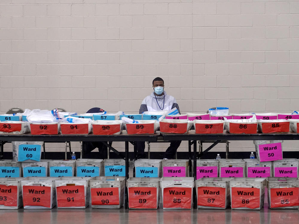 An election official pauses during the ballot recount earlier this month at the Wisconsin Center in Milwaukee. After recounts in Milwaukee and Dane counties, President-elect Joe Biden narrowly increased his winning margin over President Trump.