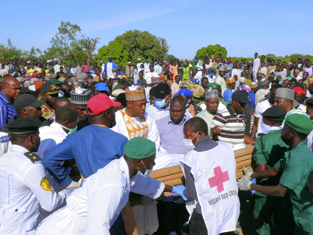 People attend a funeral for those killed by suspected Boko Haram militants in Zabarmari, Nigeria on Sunday. Officials say armed men on motorcycles reportedly killed at least 70 rice farmers and fishermen while they were harvesting crops in northern Borno state.