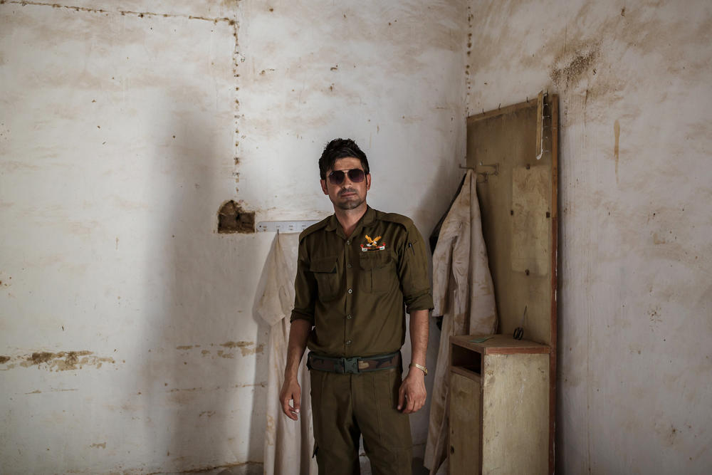 Saeed Murad, the brother of Yazidi activist and Nobel Peace laureate Nadia Murad, visits his former family home in Kocho, northern Iraq. A white cloak that his mother used to wear hangs in the corner behind him. Murad is one of the few survivors from Kocho. Shot six times by a young ISIS fighter, he was left for dead among the bodies.