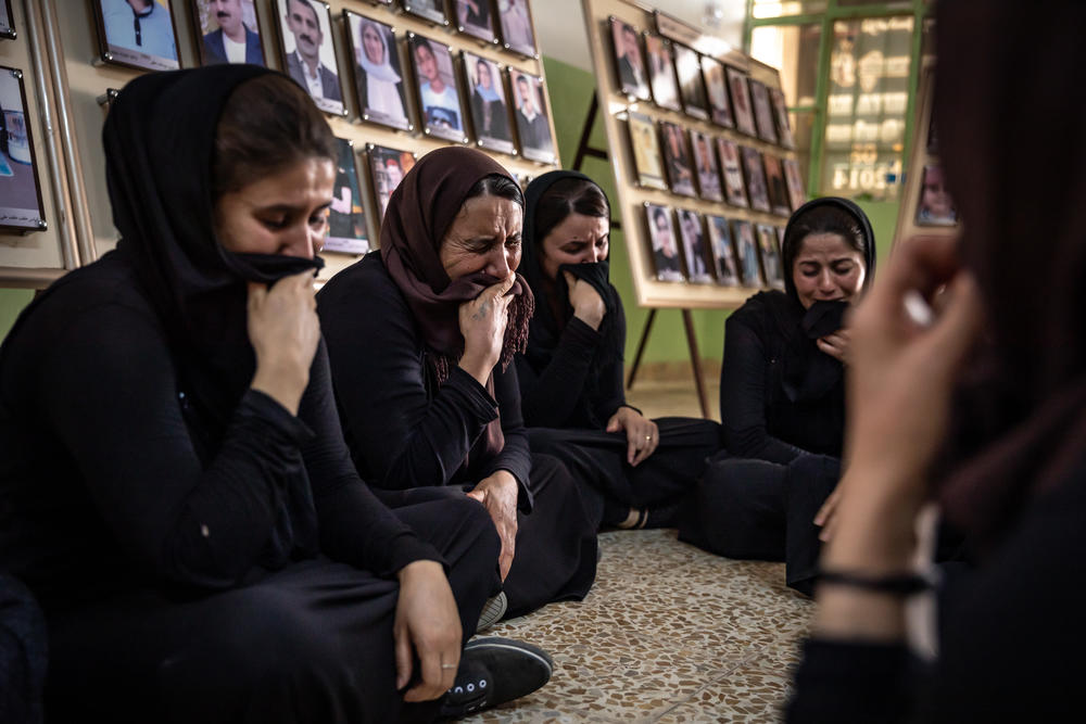 Women from Kocho weep for the victims of the genocide. Convoys of ISIS fighters invaded the Sinjar region, intent on eradicating Yazidi religion. Kurdish security forces in charge of the region retreated, leaving the Yazidis defenseless.