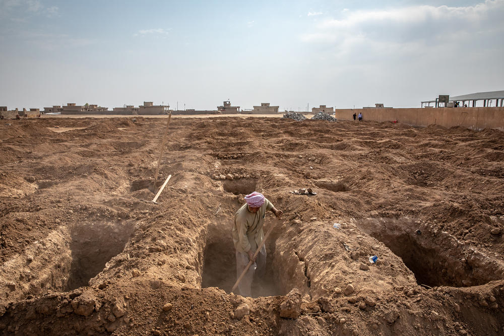 A man from a group of Yazidi survivors and volunteers digs new graves in 2019 to properly bury family members whose remains were discovered in mass graves in the Yazidi village of Kocho, northern Iraq. Now, a year later, many family members are still waiting for the bodies to undergo DNA testing and be returned to them.
