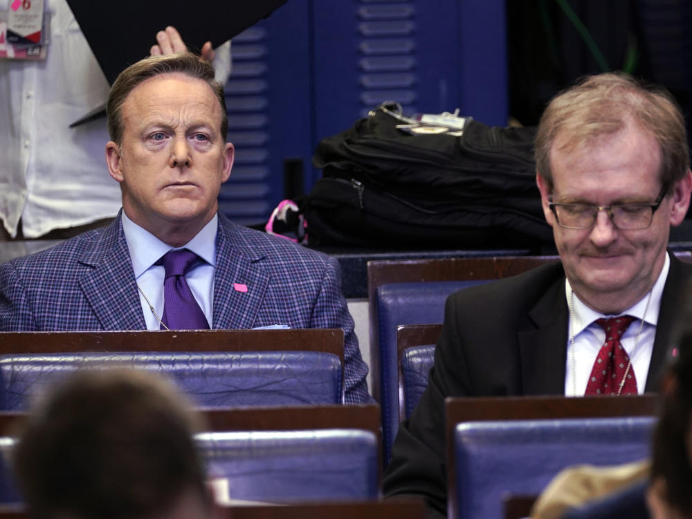Sean Spicer (left), the former White House press secretary and an on-air personality for Newsmax, listens during a March coronavirus task force briefing at the White House.