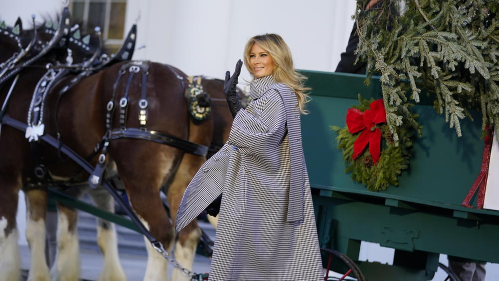 First lady Melania Trump waves as she stands next to the 2020 Official White House Christmas tree as it is presented on the North Portico of the White House, Monday, Nov. 23, 2020, in Washington. (AP Photo/Andrew Harnik)