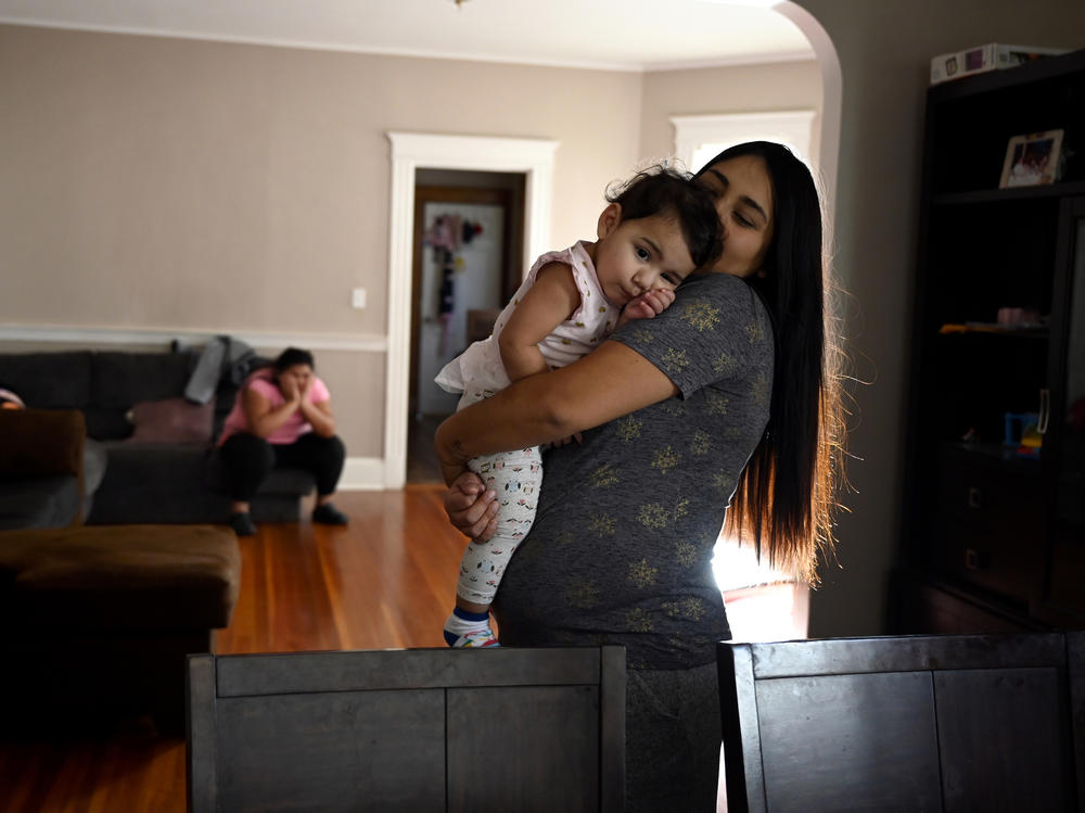 Peruvian refugee Xiomy De la Cruz holds her 13-month-old daughter, Maia, last month in her Hartford, Conn., home, which was once filled with donations of food and sundries as part of the food pantry she has set up during the pandemic.
