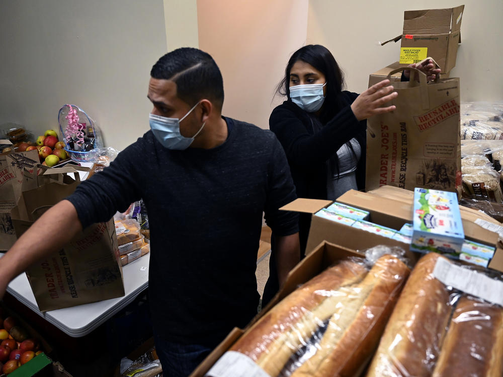 Ingmar Riveros and Peruvian refugee Xiomy De la Cruz distribute food from a store basement last month in Hartford, Conn.