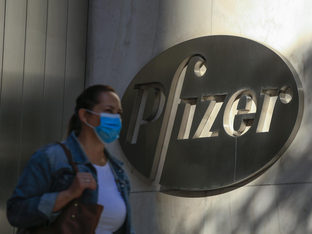 A woman wears a mask as she walks by Pfizer's world headquarters in New York last month.