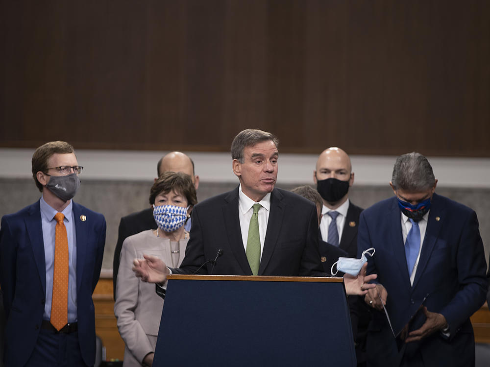 Sen. Mark Warner speaks alongside a bipartisan group of lawmakers as they announce a proposal for a $908 billion coronavirus relief bill on Tuesday.